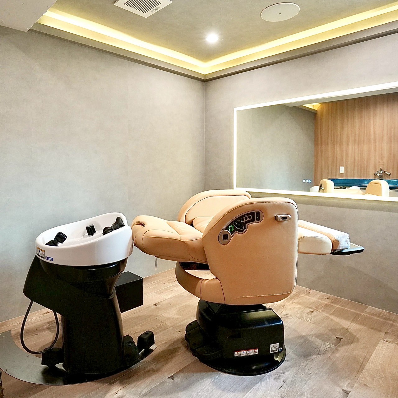 美容室の実績事例 - Growth Partners Japanによる運用代行で平均予約増加率165%を達成 モダンな美容室の内装、ベージュのスタイリングチェアとシャンプー台が配置された高級感のある空間